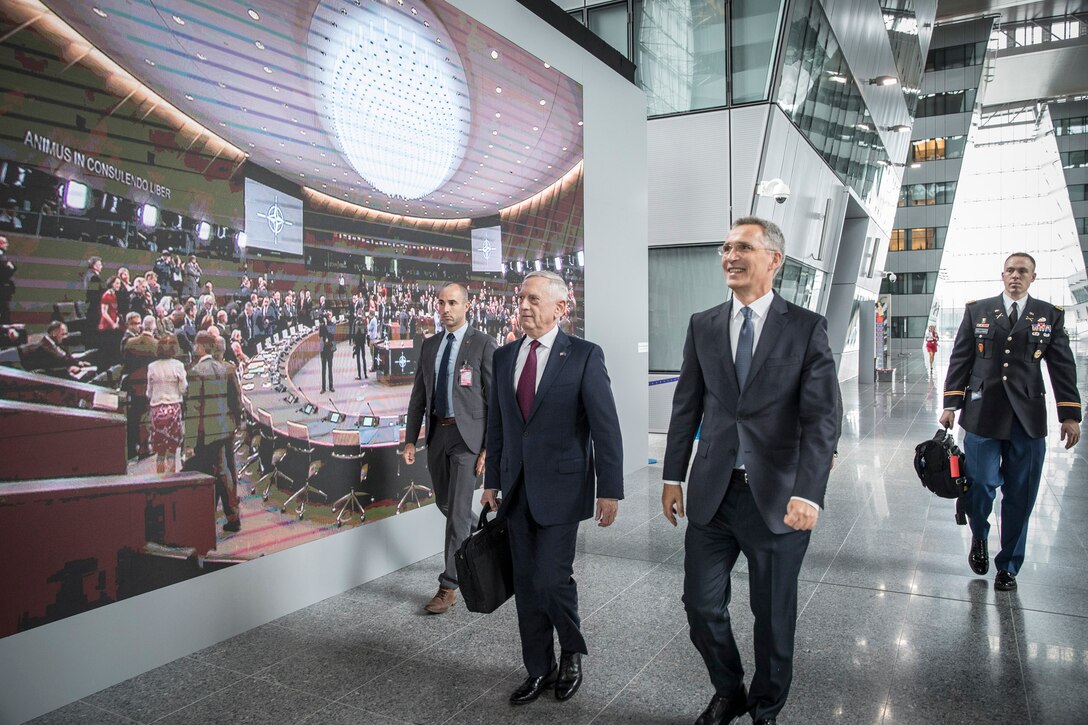 Men walk down a hall.