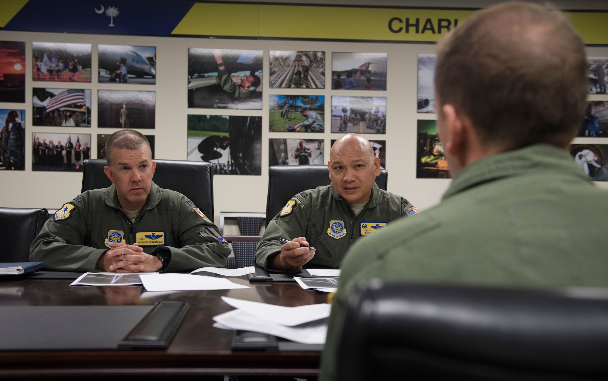 Col. Patrick Winstead, left, 437th Airlift Wing vice commander, and Col. Jimmy Canlas, middle, 437th Airlift Wing commander, discuss a proposal to enhance runway operations at North Auxiliary Airfield, North, S.C., with Maj. Ron Howard, 437th Operations Squadron assistant director of operations, during the Squadron Innovation Fund panel meeting June 4, 2018.