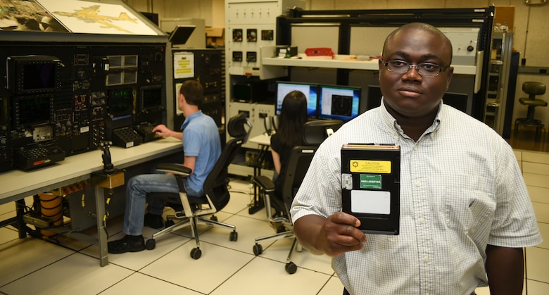 Emmanuel Koomson, 557th Software Maintenance Squadron lead test engineer holds a data transfer cartridge for the B-52H which contains the latest software upgrades developed by his team in the Mission Planning Environment section in the B-52 software test lab on May 29, 2018, Tinker Air Force Base, Oklahoma.