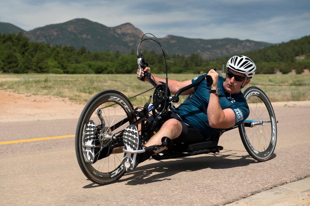 Navy Chief Petty Officer Mathew Parker turns a hand cycle along the 2018 DoD Warrior Games time trials competition course during the Department of Defense Warrior Games at the U.S. Air Force Academy in Colorado Springs, Colo.