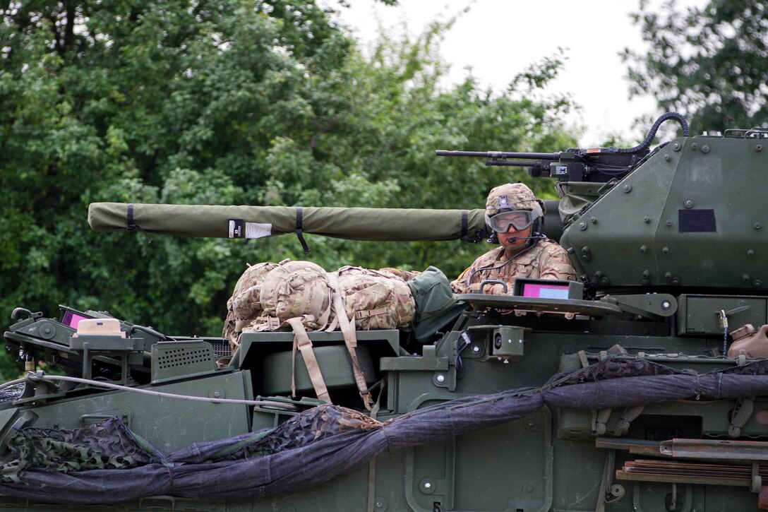 A soldier waits in his tactical vehicle for members of his crew to return.