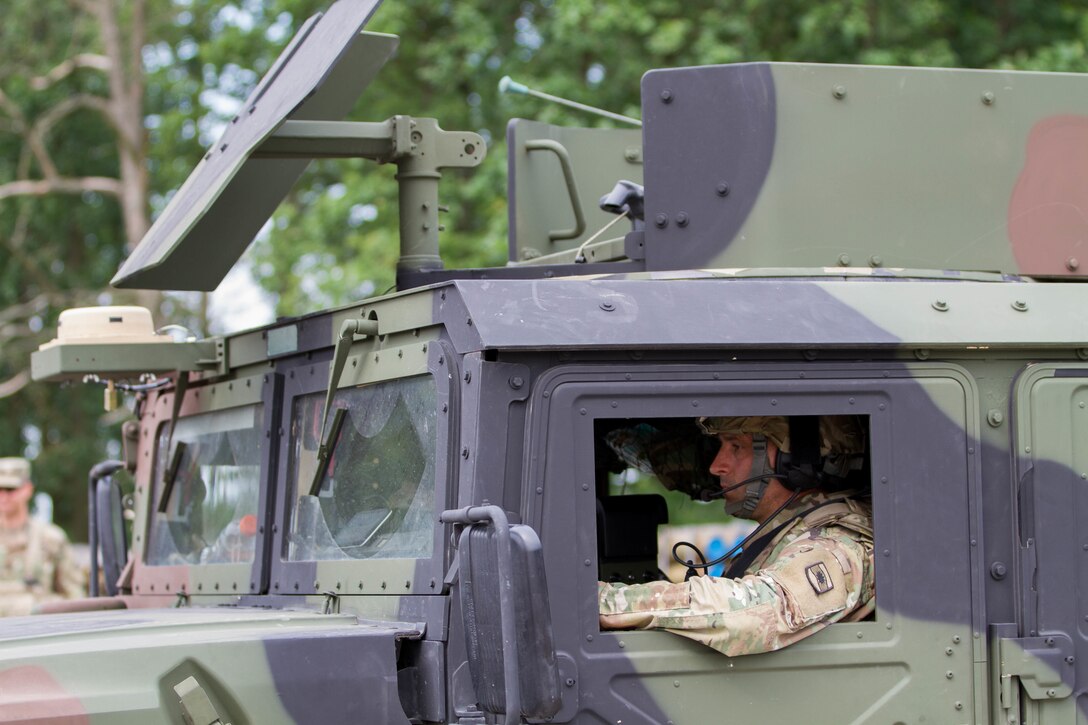 A soldier driving a Humvee waits in line at the ammunition distribution.