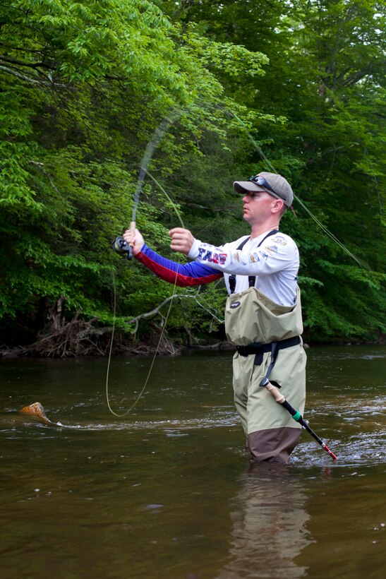 A Marine casts out a line during a fly fishing event.