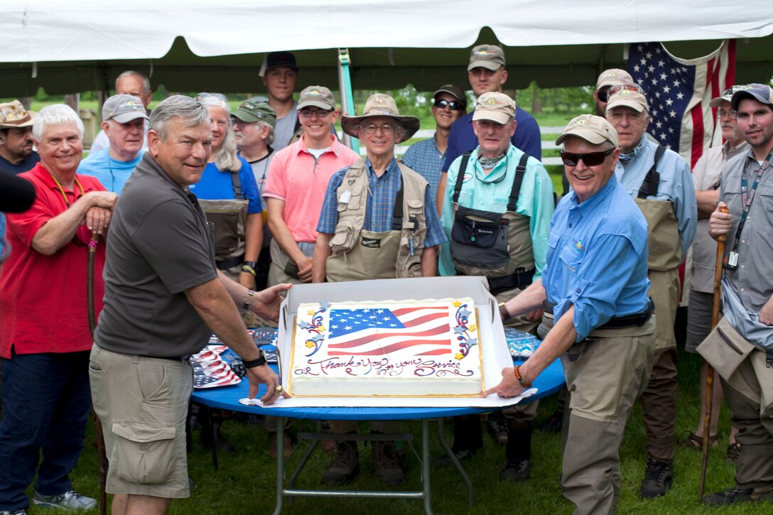 Project Healing Waters volunteers present a cake to service members after a day of fly fishing.