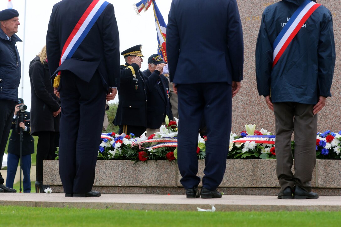 Commander and veteran render a salute during the 74th D-Day commemoration ceremony.