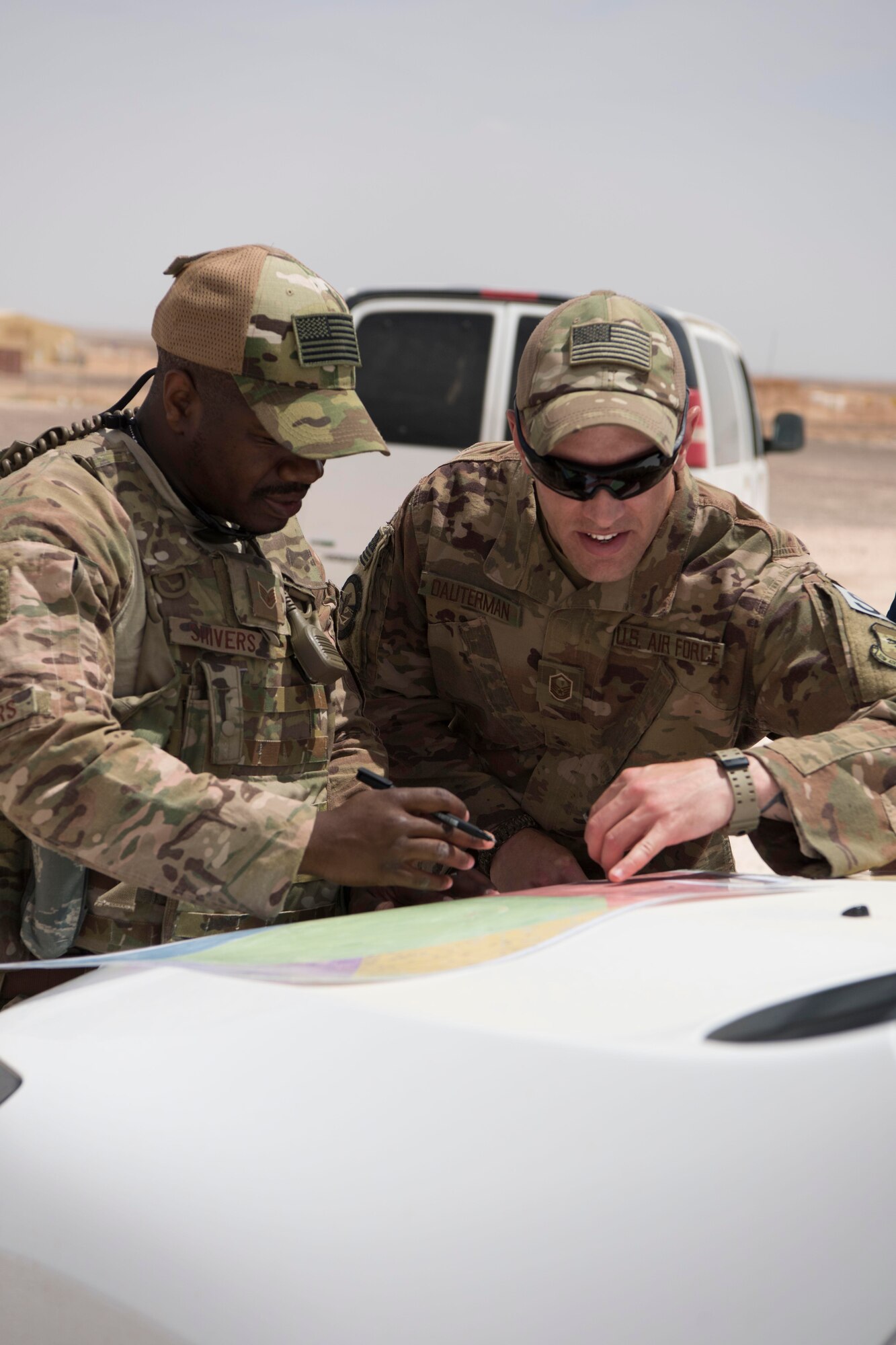 Staff. Sgt. Chadir Shiver (left), 332nd Expeditionary Security Forces battle captain, and Master Sgt. Jared Dauterman, 332nd ESFS NCO in charge of operations, review a map during an exercise at an undisclosed location in Southwest Asia, May 28, 2018.