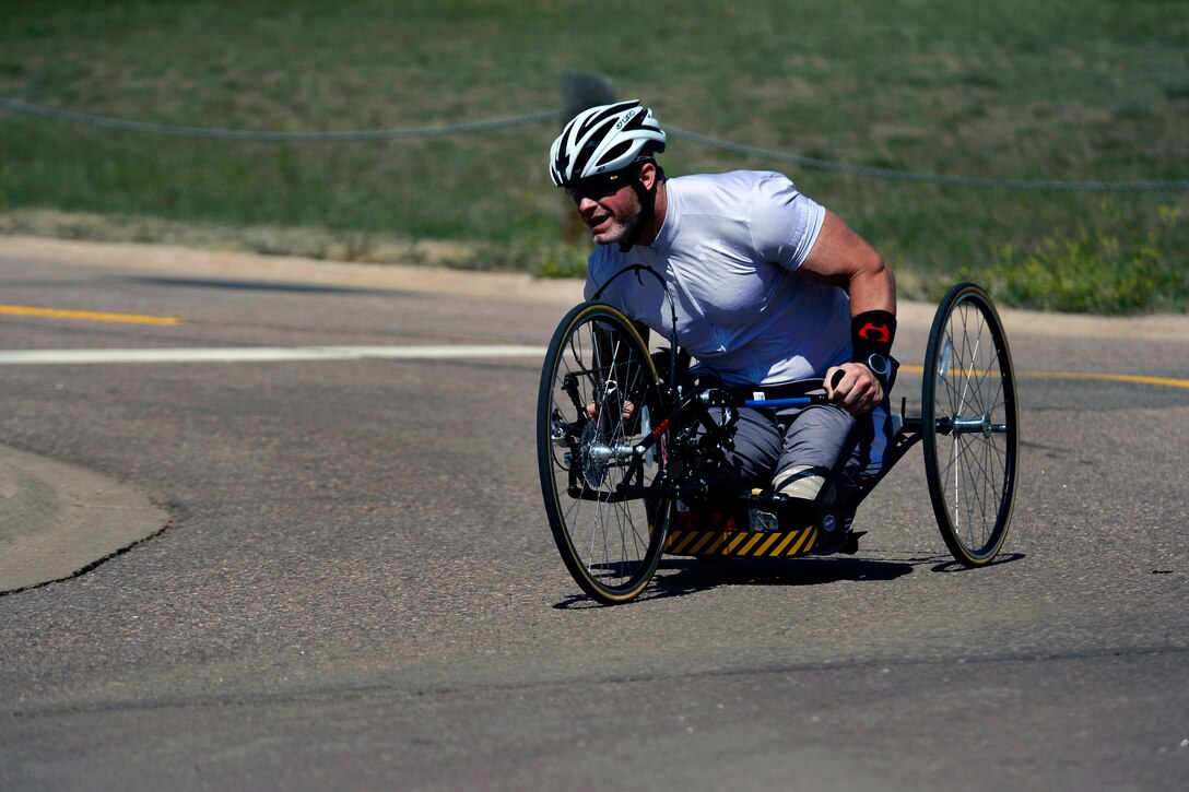 A soldier wins his time trial in the seated recumbent bike division.