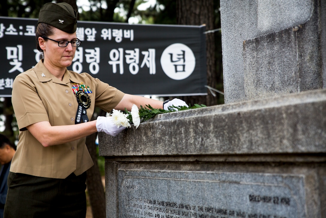U.S. Marine Col. Maria McMillen places a flower on the 1st Marine Aircraft Wing Memorial Monument during a memorial ceremony at Pohang City Battle Monument and 1st MAW Memorial Monument in Pohang, South Korea, June 6, 2018. One at a time, each guest placed a flower on the memorial. McMillen, a Craig, Colorado native, is the G-5 assistance chief of staff with 1st MAW.