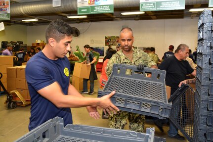 Petty Officer 1st Class Milton Duarte (right), a recruiter assigned to Navy Recruiting Station De Zavala, Navy Recruiting District San Antonio, and Diego Rodriguez, a future Sailor from Del Rio, Texas, volunteers at the San Antonio Food Bank during a Delay Entry Program meeting June 6.  Duarte, a 2003 graduate of South Bronx High School, joined the Navy in 2005.  Rodriguez, a 2014 graduate of Del Rio High School, will serve as an electrician’s mate in America’s Navy.