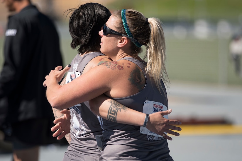 Army Staff Sgt. Lauren Montoya, left, hugs her U.S. Special Operations Command teammate, former Marine Corps Reserve Gunnery Sgt. Tiffany Hudgins, after a track-and-field race at the 2018 Department of Defense Warrior Games at the U.S. Air Force Academy in Colorado Springs, Colo.