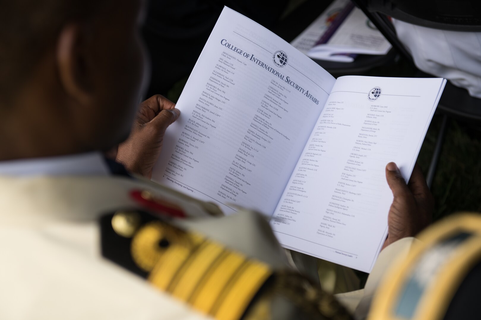 Foreign military graduate browses the program during  the National Defense University (NDU) Graduation