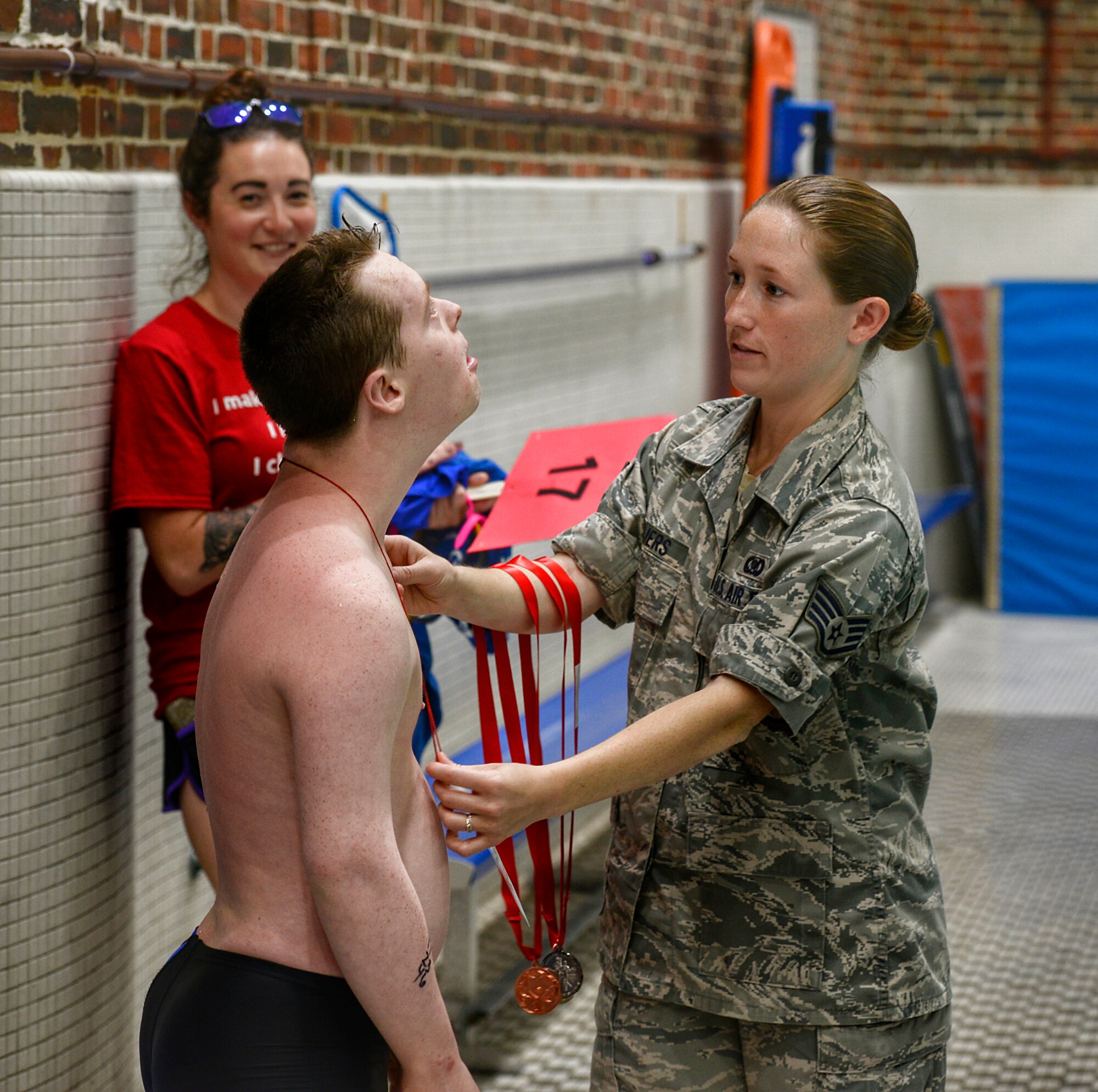 Staff Sgt. Beverly C. Meijers presents her brother, Simon Cole, with an award for his participation in the 25 meter swimming event during the Summer 2018 N.H. Special Olympics on June 1, 2018 at the University of New Hampshire Swasey pool in Durham, N.H. Meijers, a 157th Air Refueling Wing command post controller, volunteered to support the Special Olympics as a way to support her brother and her community. (N.H. Air National Guard photo by Staff Sgt. Kayla White)