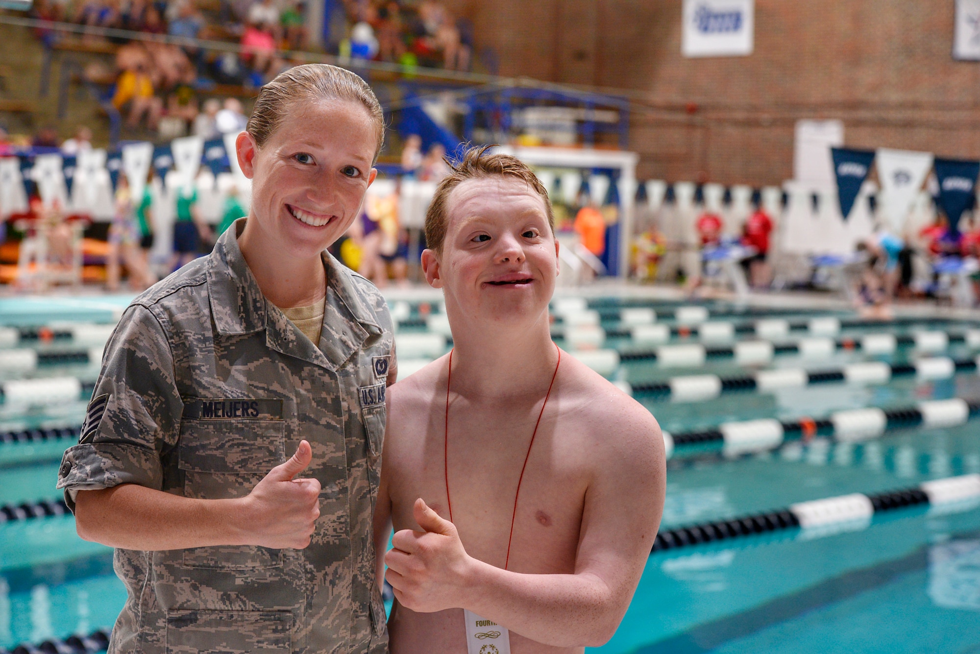 Staff Sgt. Beverly C. Meijers, 157th Air Refueling Wing command post controller, poses for a portrait with her brother, Simon Cole, on June 1, 2018 at the University of New Hampshire Swasey Pool in Durham, N.H. Meijers presented Cole with an award for his participation in the 25 meter swimming event during the Summer 2018 N.H. Special Olympics. (N.H. Air National Guard photo by Staff Sgt. Kayla White)