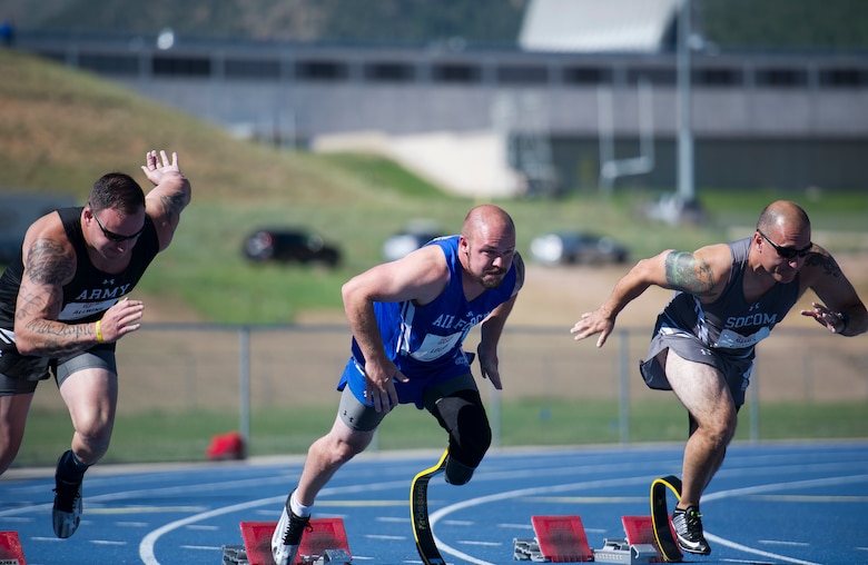 Army Staff Sgt. Ross Alewine, left, Air Force veteran Russell Logan, and Army 1st Sgt. Jarrid Collins of Team SOCOM (U.S. Special Operations Command), leave the starting blocks of the 100-meter track event, June 2, 2018, at the Department of Defense Warrior Games. The Warrior Games, taking place June 1-9, 2018, at the U.S. Air Force Academy in Coloo. are a paralympic-style competition for wounded, and injured service members from all U.S. branches of service and this year include teams from the United Kingdom Armed Forces, Australian Defense Force and Canadian Armed Forces. (DoD photo by Master Sgt. Stephen D. Schester)