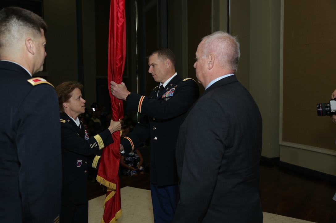 Brig. Gen. Diana Holland, Commander of the U.S. Army Corps of Engineers South Atlantic Division, passes the Corps flag to Col. Daniel Hibner, incoming commander for the Corps' Savannah District during a change of command ceremony June 8, 2018. The passing of the colors symbolizes the formal relinquishing of command from outgoing commander Col. Marvin Griffin to incoming commander Hibner. USACE photo by David Kimery.