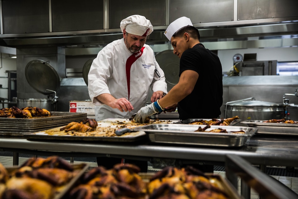 Food service specialists prepare chicken for the Phelps Mess Hall grand re-opening aboard the Marine Corps Air Ground Combat Center, Twentynine Palms, Calif., June 4, 2018.  Phelps Hall has been closed since November 11, 2017, due to renovations to improve the efficiency of the facility. (U.S. Marine Corps photo by Lance Cpl. Margaret Gale)