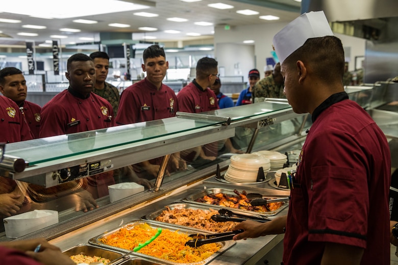 Cpl. Jose Sanchez, chief chef, Headquarters Battalion, conducts a line critique before the grand re-opening of Phelps Mess Hall aboard the Marine Corps Air Ground Combat Center, Twentynine Palms, Calif., June 4, 2018. Phelps Hall has been closed since November 11, 2017, due to renovations to improve the efficiency of the facility. (U.S. Marine Corps photo by Lance Cpl. Margaret Gale)
