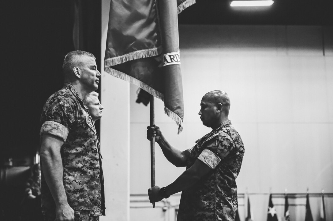 Sgt. Maj. Michael B. Dutchin off-going commanding general, Marine Corps Air Ground Combat Center, exchanges the guidon with Brig. Gen. Roger Turner, on-coming commanding general, MCAGCC, during the installation’s change of command ceremony aboard the Combat Center, Twentynine Palms, Calif., June 8, 2018. The change of command ceremony ensures that the unit and its Marines are never without official leadership, and also signifies an allegiance of Marines to their unit commander. (U.S. Marine Corps photo by Lance Cpl. William Chockey)