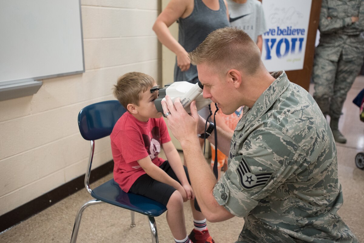 Staff Sgt. Jonathon Engler, an optometry technician from the 167th Medical Group, West Virginia Air National Guard, checks a child’s vision at Graves County High School in Mayfield, Ky., July 20, 2016, during an Innovative Readiness Training exercise. The Kentucky Air National Guard and U.S. Navy Reserve are performing a similar IRT exercise in Eastern Kentucky this month, providing no-cost medical, dental and optometry care to underserved residents. (U.S. Air National Guard photo by Master Sgt. Phil Speck)