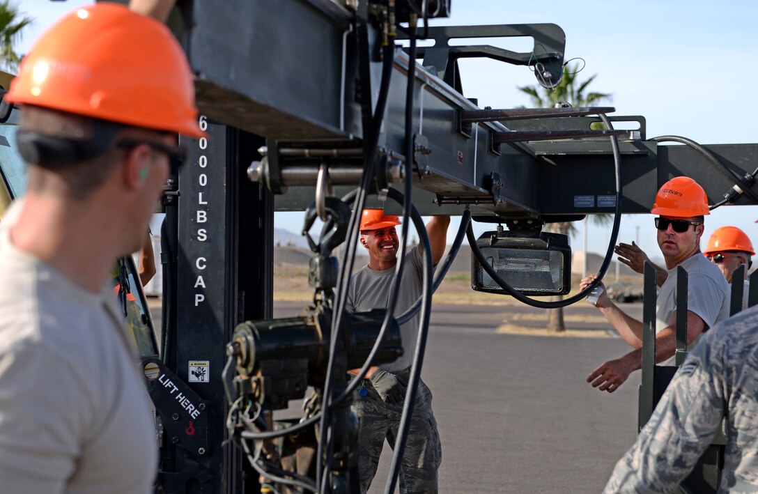 Air Force Combat Munitions competition team members from the 56th Equipment Maintenance Squadron munitions flight setup bomb assembly utilities during a practice run June 6, 2018, at Luke Air Force Base, Ariz. Challenges for the competition include munitions assembly conveyor setup, bomb-building, and inventory inspection. (U.S. Air Force photo by Senior Airman Ridge Shan)