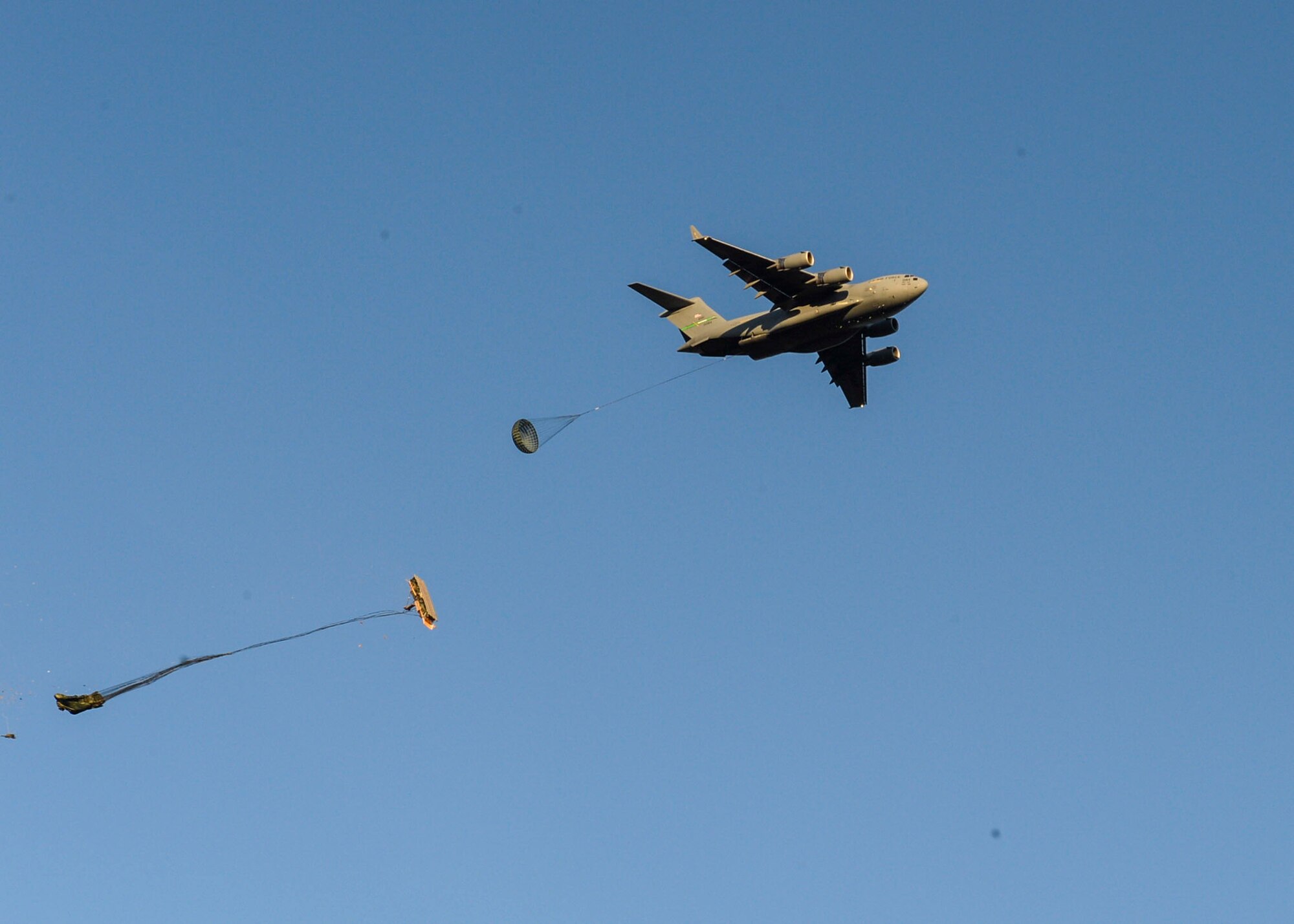 A U.S. Air Force C-17 Globemaster drops supplies over a drop zone in Adazi, Latvia, June 9, 2018. Four aircraft from the 62nd Airlift Wing at Joint Base Lewis-McChord, Washington and four aircraft from the 437th Airlift Wing at Joint Base Charleston, South Carolina provided support to exercise Swift Response 18. Swift Response included approximately 2,300 participants from seven allied nations to help train the U.S. Global Response Force, led by the U.S. Army’s 82nd Airborne Division, in Joint Forcible Entry operations. (U.S. Air Force photo by Jimmie D. Pike)