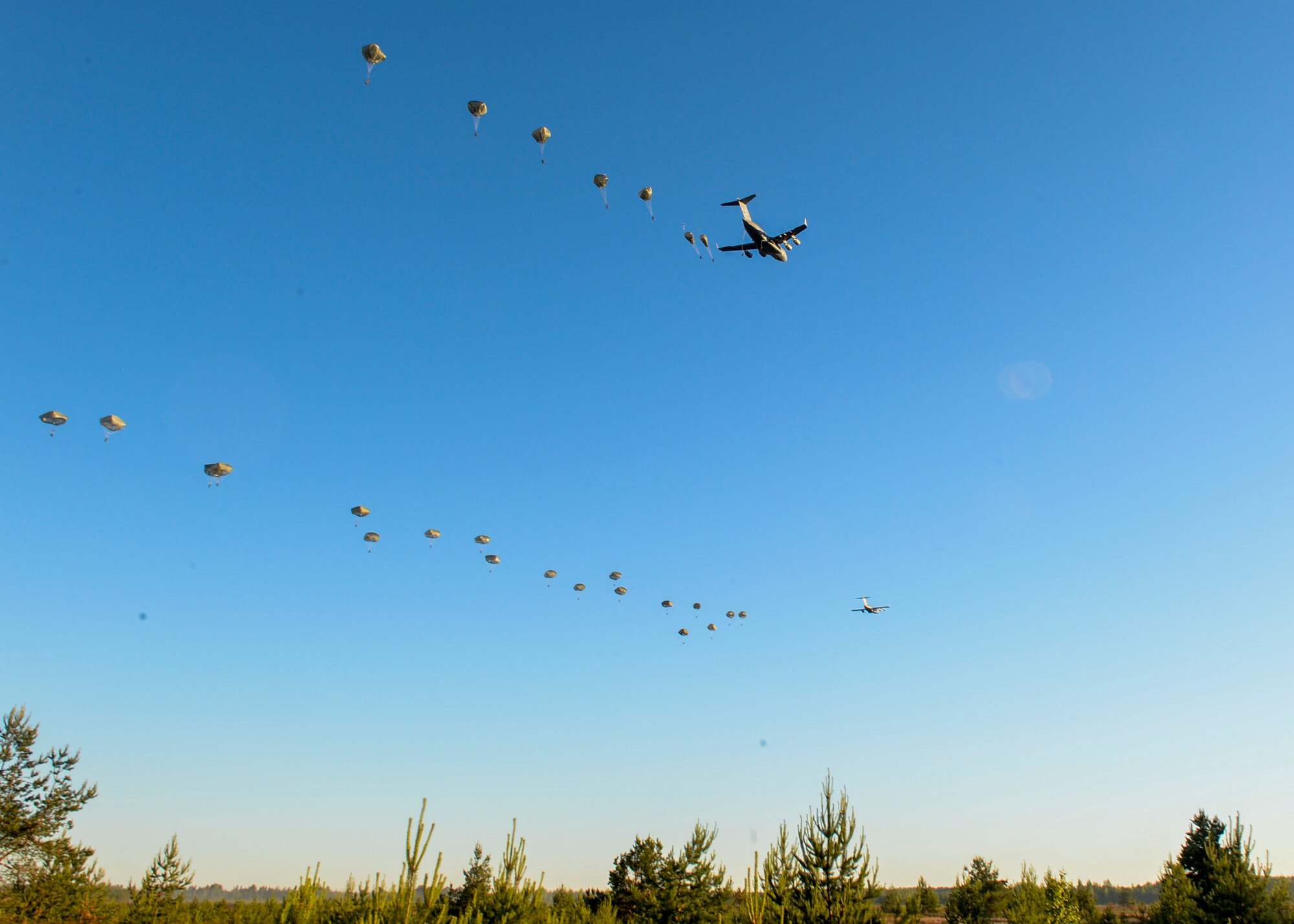 82nd Airborne Paratroopers jump from U.S. Air Force C-17 Globemasters over a drop zone in Adazi, Latvia, June 9, 2018. Four aircraft from the 62nd Airlift Wing at Joint Base Lewis-McChord, Washington and four aircraft from the 437th Airlift Wing at Joint Base Charleston, South Carolina provided support to exercise Swift Response 18. Swift Response included approximately 2,300 participants from seven allied nations to help train the U.S. Global Response Force, led by the U.S. Army’s 82nd Airborne Division, in Joint Forcible Entry operations. (U.S. Air Force photo by Staff Sgt. Jimmie D. Pike)