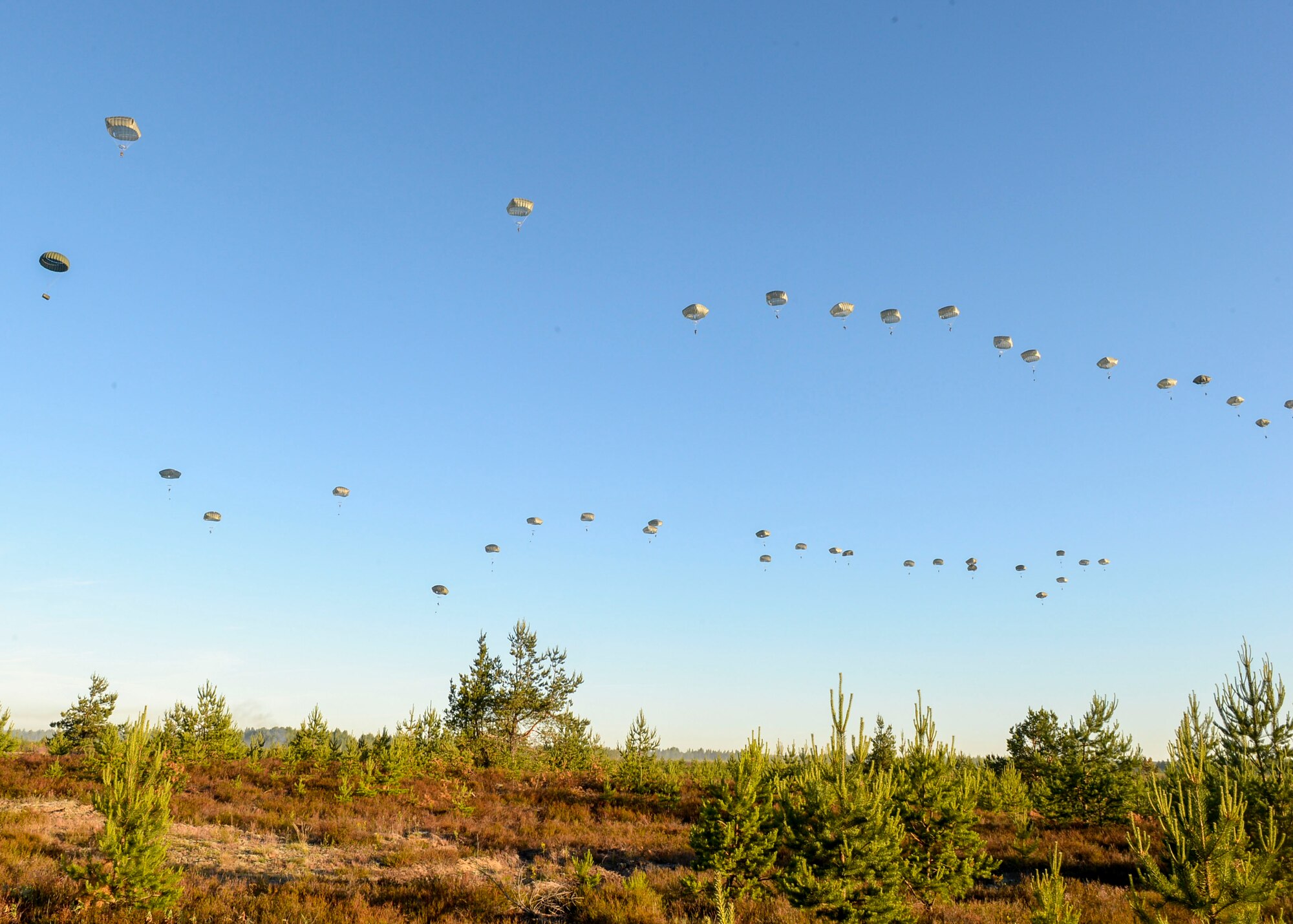 82nd Airborne Paratroopers parachute down to a drop zone in Adazi, Latvia, June 9, 2018. Four U.S. Air Force C-17 Globemasters from the 62nd Airlift Wing at Joint Base Lewis-McChord, Washington and four C-17s from the 437th Airlift Wing at Joint Base Charleston, South Carolina provided support to exercise Swift Response 18. Swift Response included approximately 2,300 participants from seven allied nations to help train the U.S. Global Response Force, led by the U.S. Army’s 82nd Airborne Division, in Joint Forcible Entry operations. (U.S. Air Force photo by Staff Sgt. Jimmie D. Pike)