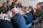 Marine Corps Gen. Joe Dunford talks while sitting at a rectangular table with U.S. and Russian officials.