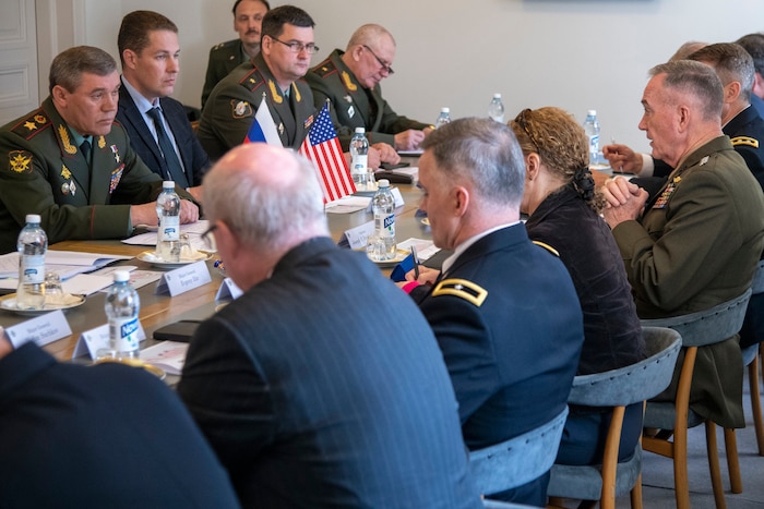 Marine Corps Gen. Joe Dunford talks while sitting at a rectangular table with U.S. and Russian officials.