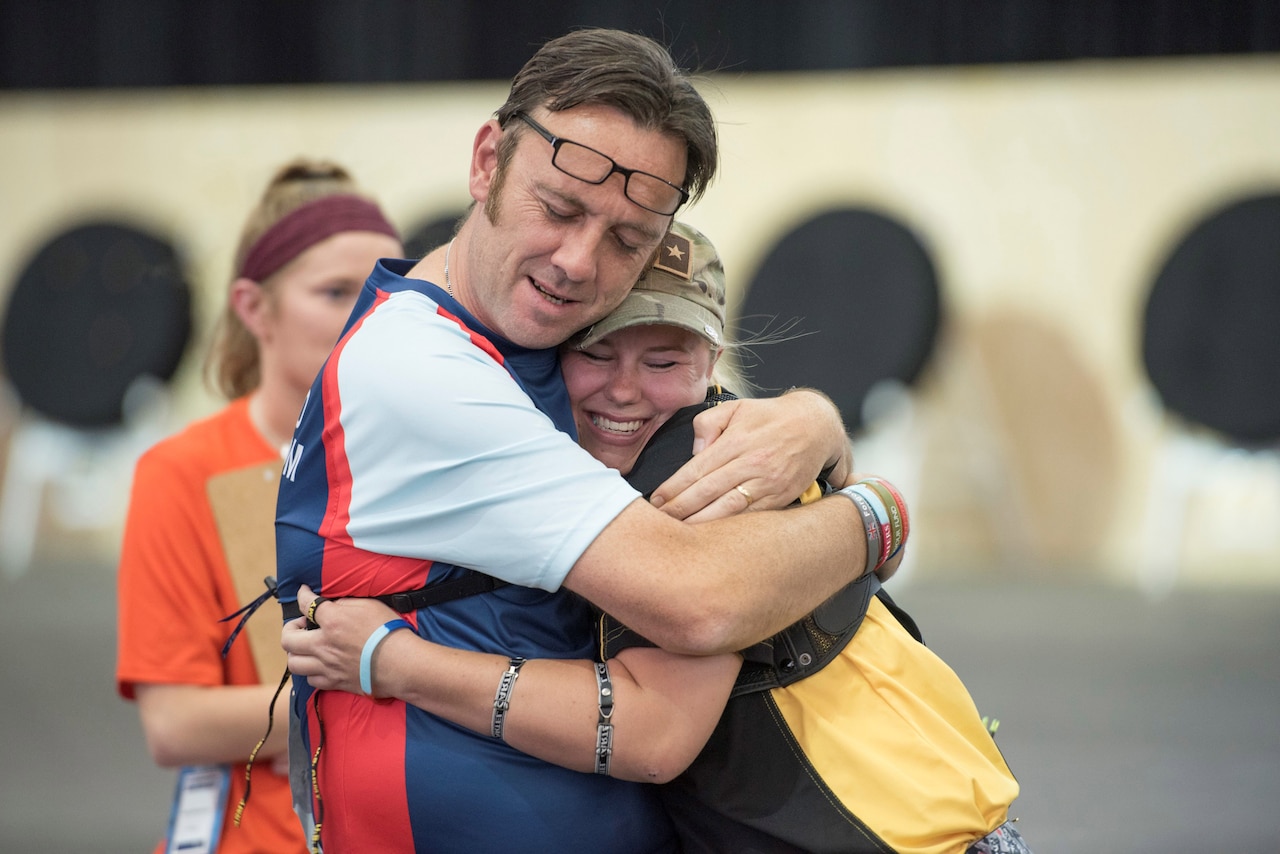 DoD Warrior Games archery competitors hug.