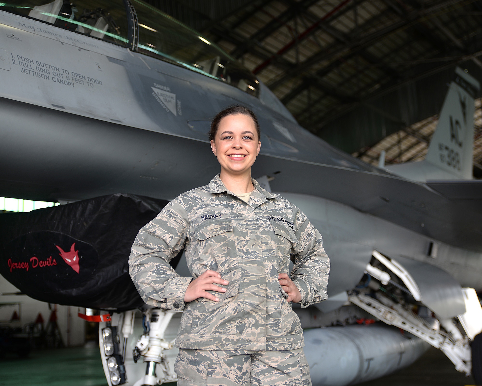 A picture of U.S. Air Force Senior Airman Samantha M. Massey, an aerospace ground equipment Airman with the 177th Fighter Wing,  posing for a portrait in front on an F-16C Fighting Falcon.