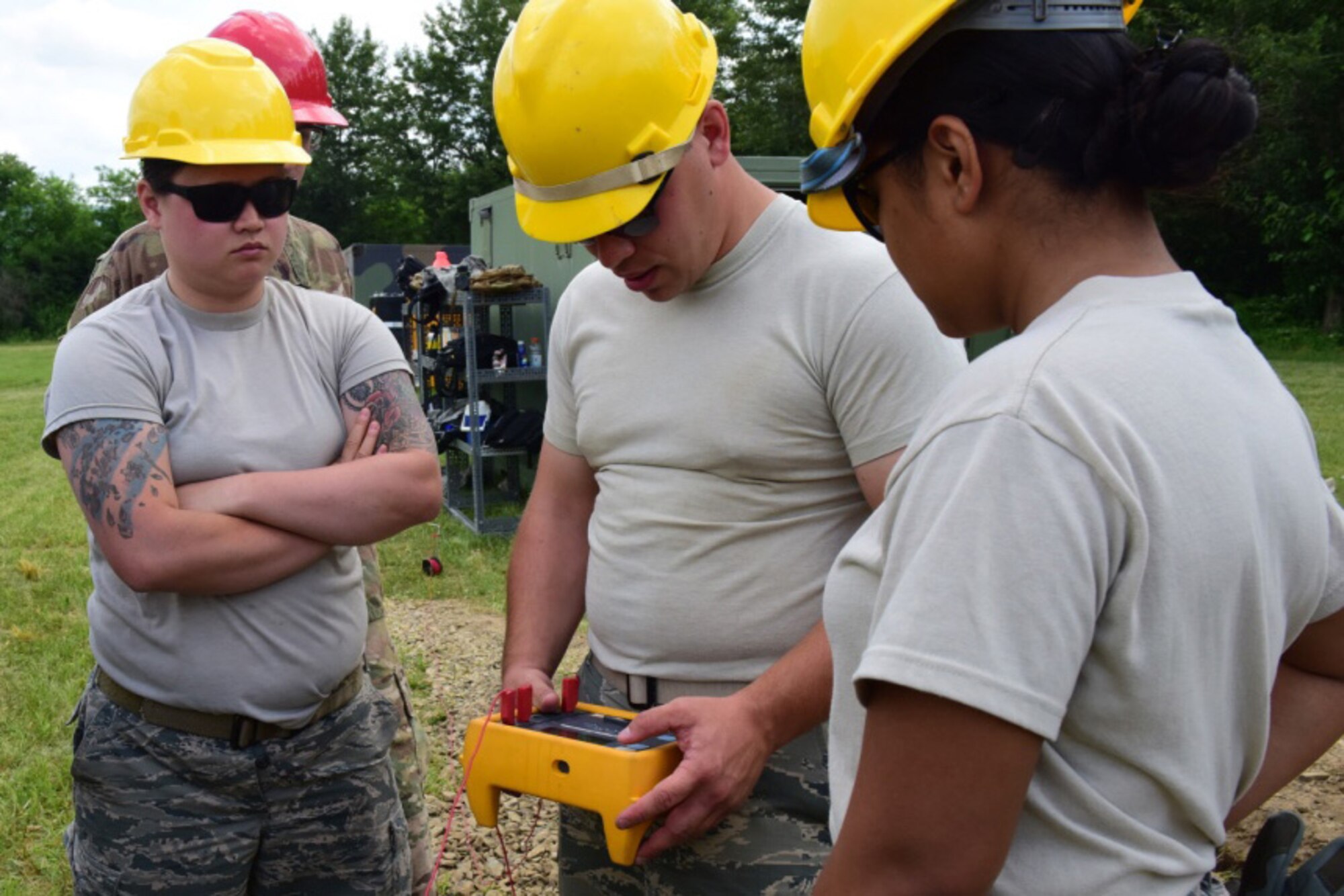 Airmen with the 211th Engineering Installation Squadron, Fort Indiantown Gap, Pennsylvania, measure the current in the ground during the squadron competition June 8, 2018. In order to measure the ground current correctly, the current must be measured from the central location of the work site. (U.S. Air National Guard photo by Senior Airman Julia Sorber/Released)