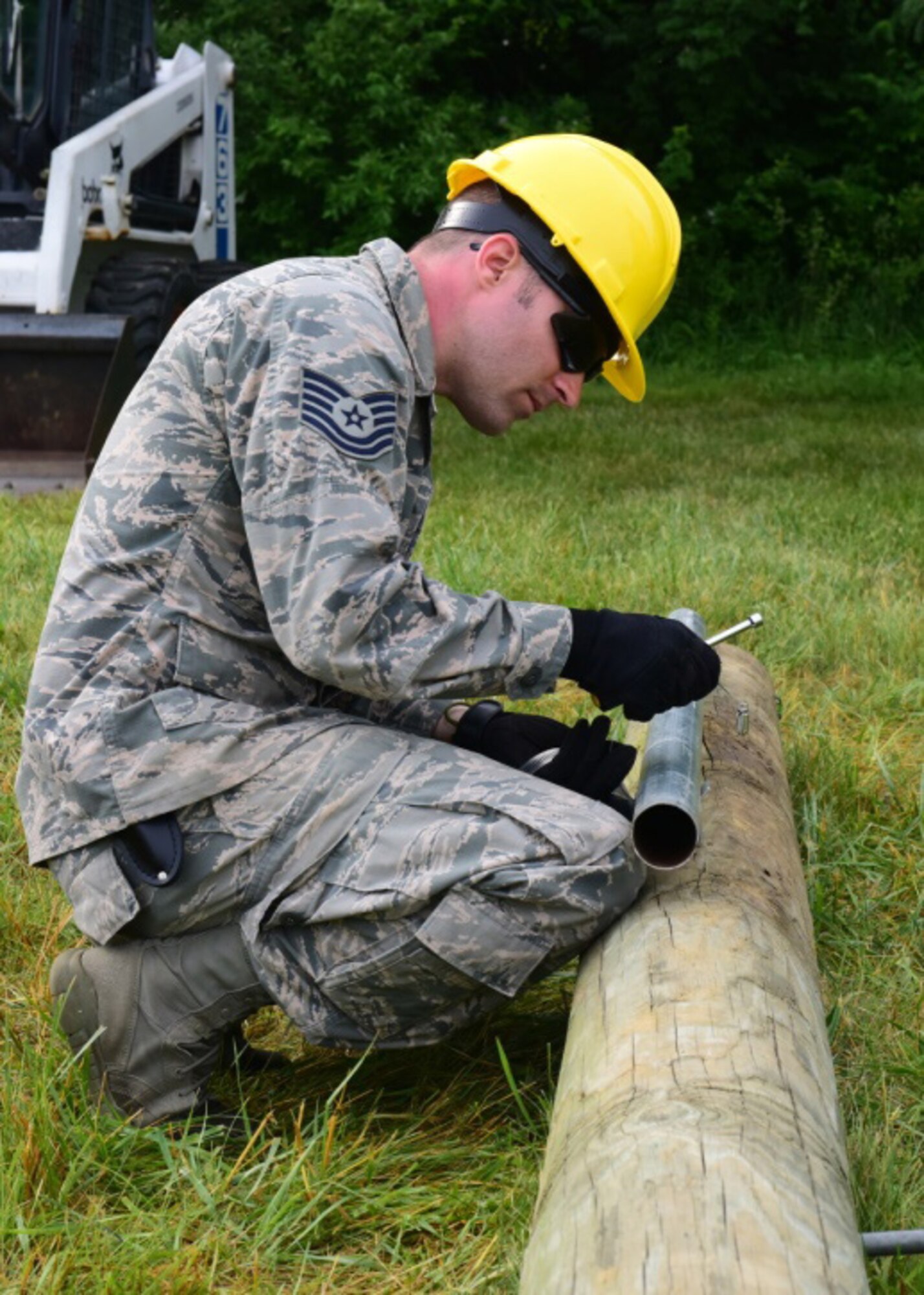 Tech. Sgt. Andrew Kindler, a cable and antenna systems specialist with the 211th Engineering Installation Squadron, Fort Indiantown Gap, Pennsylvania, install lightening protection to a telephone pole during the squadron competition June 8, 2018. Lightening protection is required so a lightning surge goes into the ground and doesn't interfere with the local area network. (U.S. Air National Guard photo by Senior Airman Julia Sorber/Released)
