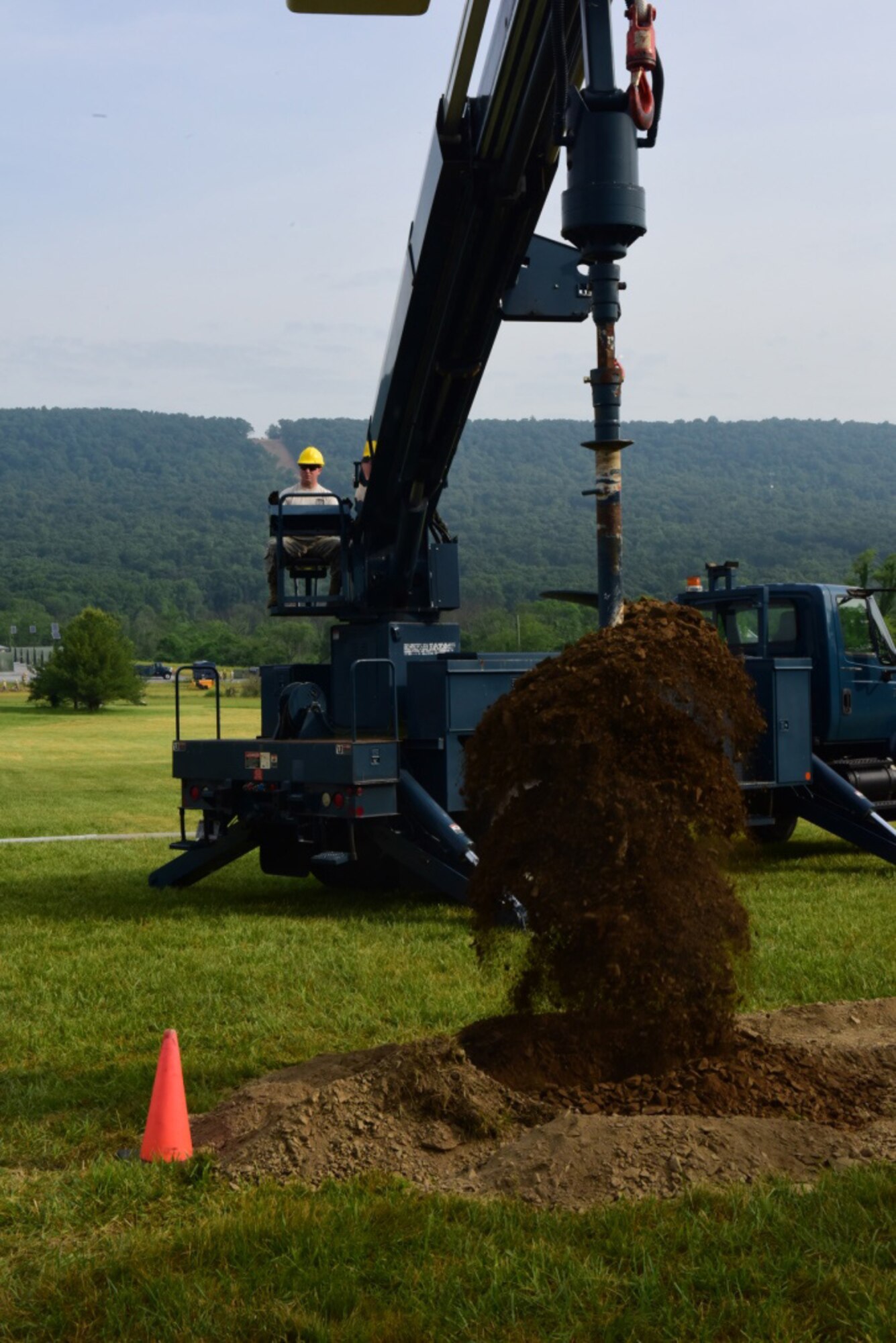 Staff Sgt. Keith Kittler, a cable and antenna systems specialist with the 211th Engineering Installation Squadron, Fort Indiantown Gap, Pennsylvania, drills the hole for a telephone pole at one work site during the squadron competition June 9, 2018. (U.S. Air National Guard photo by Senior Airman Julia Sorber/Released)