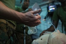Navy field medical corpsmen with 3rd Medical Battalion, 3rd Marine Logistics Group provide care to a simulated casualty at Kin Blue on Okinawa, Japan, June 6, 2018. The simulation is part of Exercise Inochi No Onjin, which increases interoperability between joint services on command and control (C2) and en-route care. The multitude of patient evacuations through the joint services increases the competency of medical units' C2, medical regulating, and role-two capabilities. (U.S. Marine Corps photo by Lance Cpl Harrison Rakhshani)
