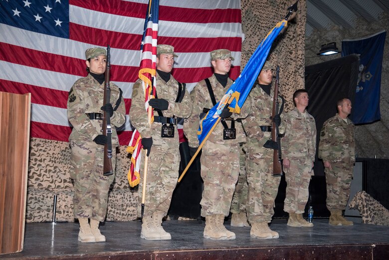 Members of the 332nd Air Expeditionary Wing honor guard prepare to post the colors during a change of command ceremony, June 9, 2018, at an undisclosed location in Southwest Asia.