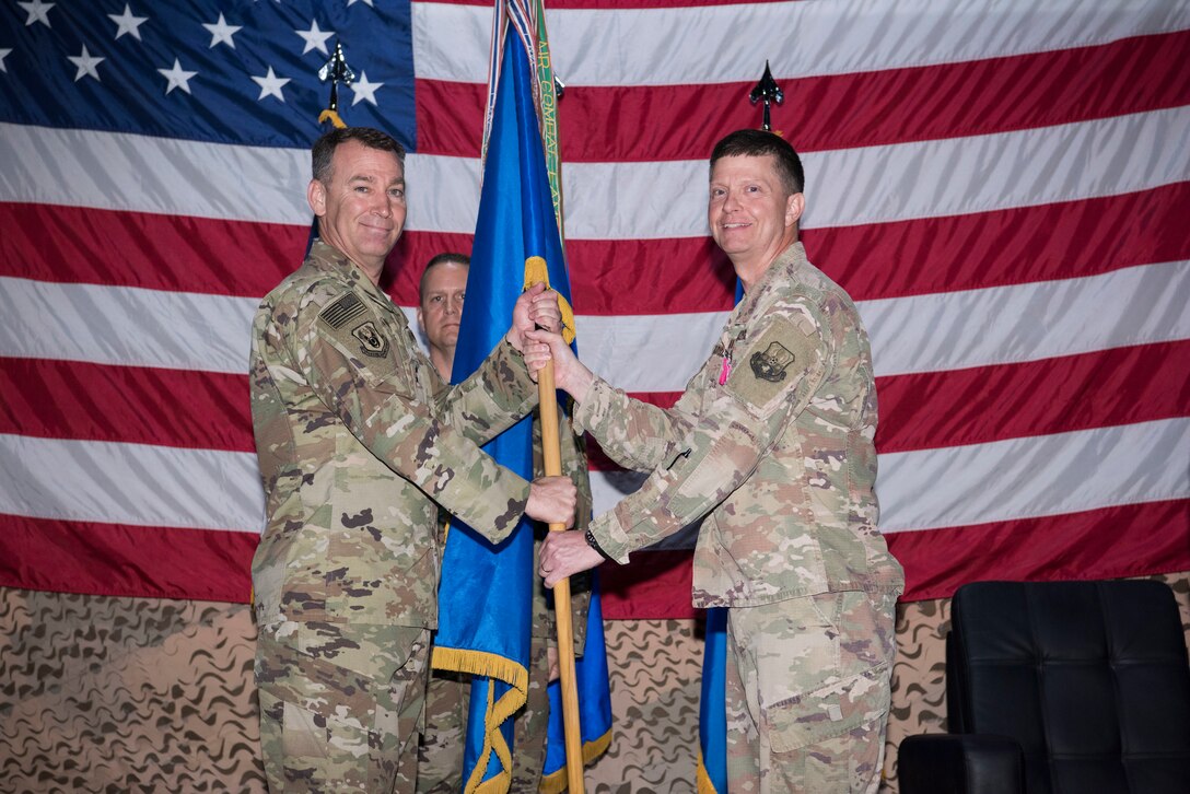 Maj. Gen. Chad Franks, 9th Air Expeditionary Task Force - Levant commander and presiding officer takes the 332nd Air Expeditionary Wing guidon from Brig. Gen. Kyle Robinson during a change of command ceremony, June 9, 2018, at an undisclosed location in Southwest Asia.