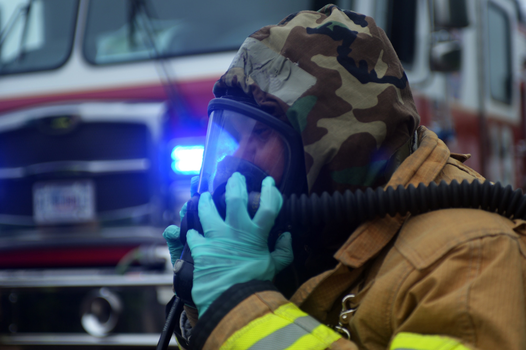 An Airman from 48th Civil Engineer Squadron adjusts his mask while responding to scenario during a readiness exercise at Royal Air Force Lakenheath, England, June 4, 2018. Exercise training emphasized a broad spectrum of elements from pre-attack preparedness, command and control, and protection of assets and personnel, to post-attack reconnaissance and self-aid buddy care for wounded wingmen. (U.S. Air Force photo by Master Sgt. Eric Burks) (Portions of this image have been obscured to protect operational security)