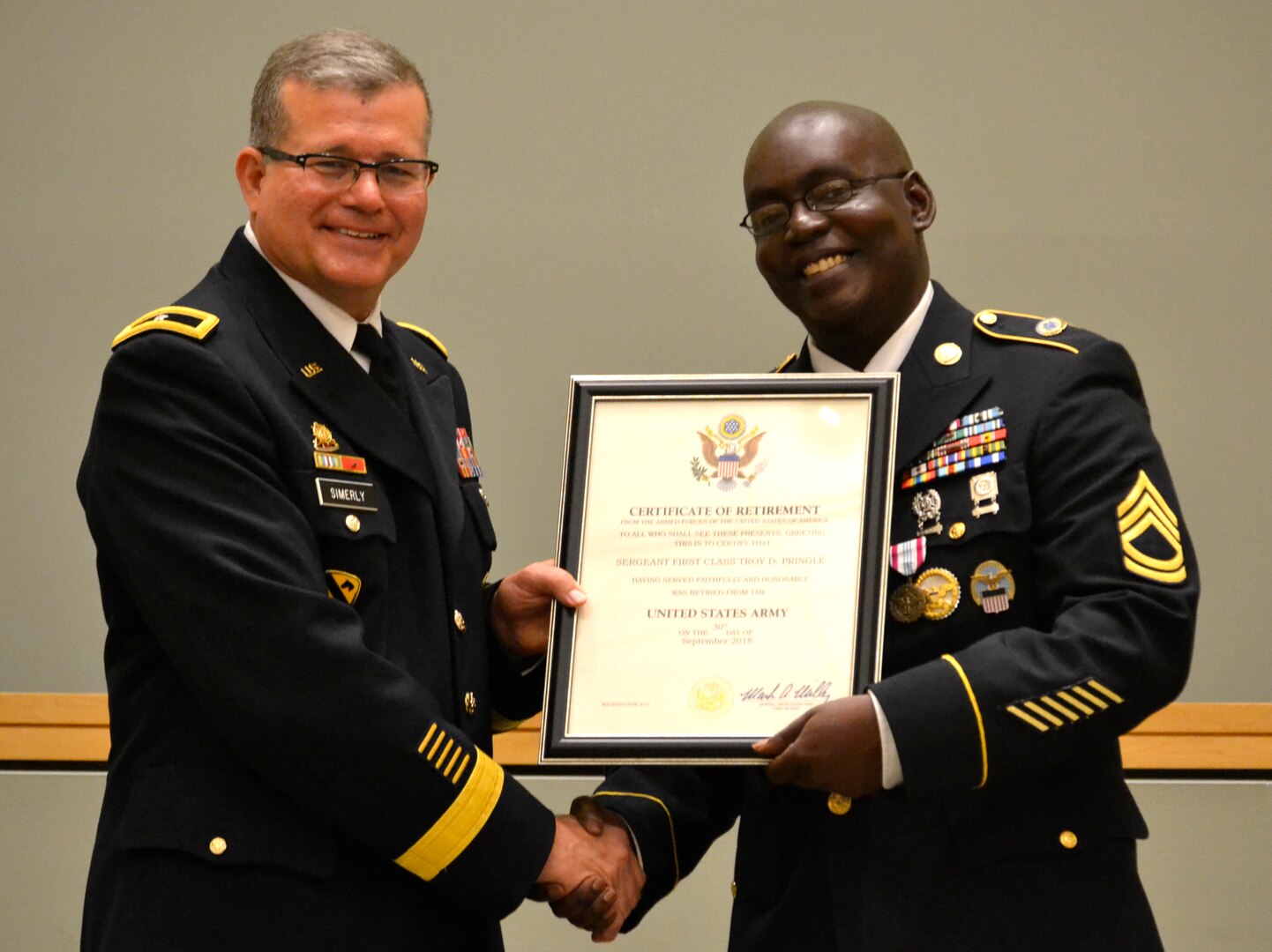DLA Troop Support Commander Army Brig. Gen. Mark Simerly (left) poses with Army Sgt. 1st Class Troy Pringle after presenting his certificate of retirement June 1 in Philadelphia. Pringle was joined by friends and family who honored his retirement after 23 years of service in the Army.