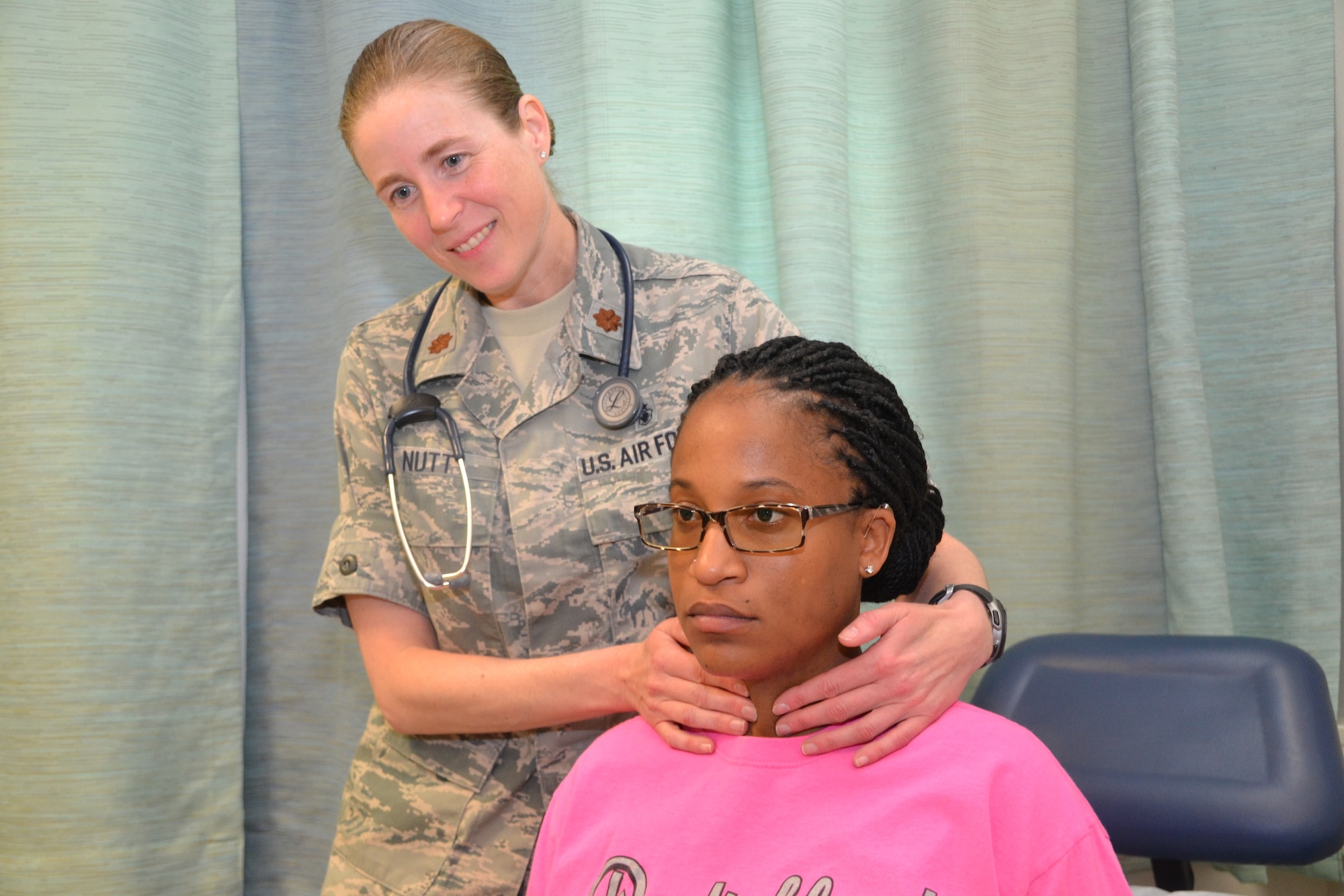 U.S. Air Force Maj. Brittany Nutt (left), a women's health nurse practitioner at Landstuhl Regional Medical Center, Germany, and consultant to the Air Force surgeon general for women's health, examines her patient's thyroid during a routine prenatal appointment. As more women join the Air Force, the role of women’s health care provider will become more important to female Airmen readiness and the health of mission. (U.S. Army photo by Gia Oney)