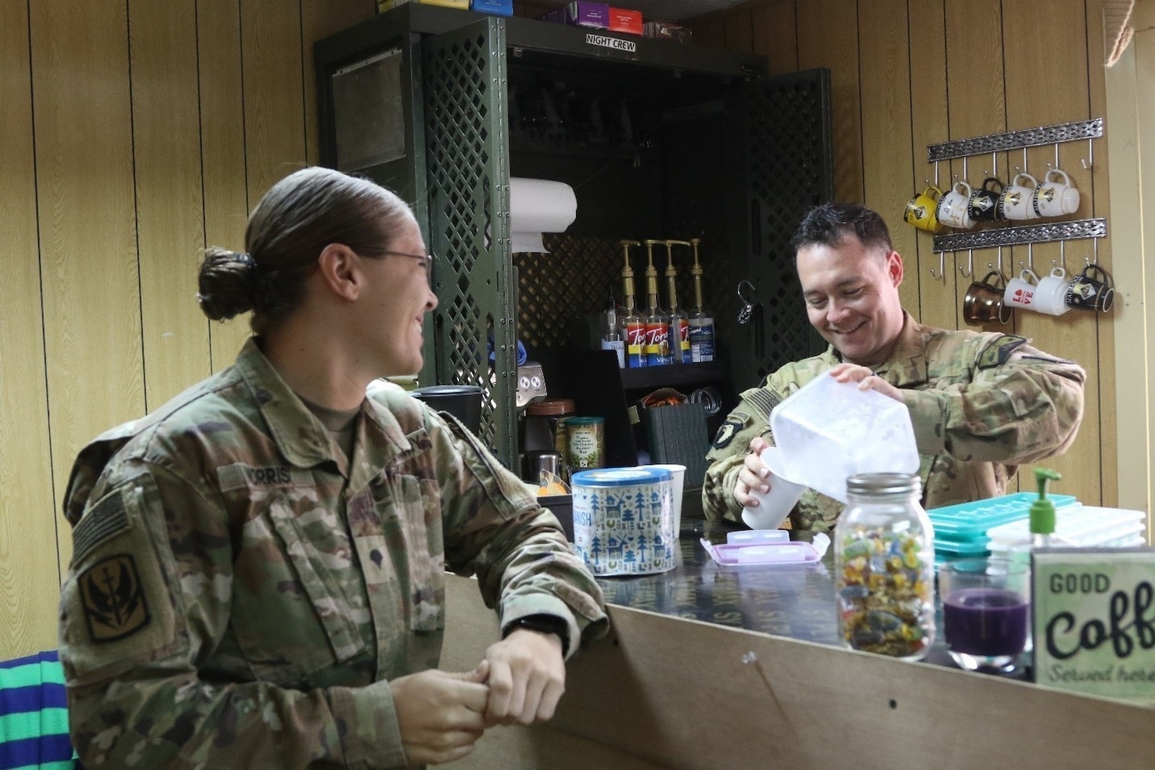 U.S. Army Chief Warrant Officer 2 Ryan Amato assigned to 1st Battalion, 189th Aviation Regiment, prepares an iced coffee for Spc Sarah Morris at the Dustoff Coffee shop at Camp Taji, Iraq May 18, 2018.