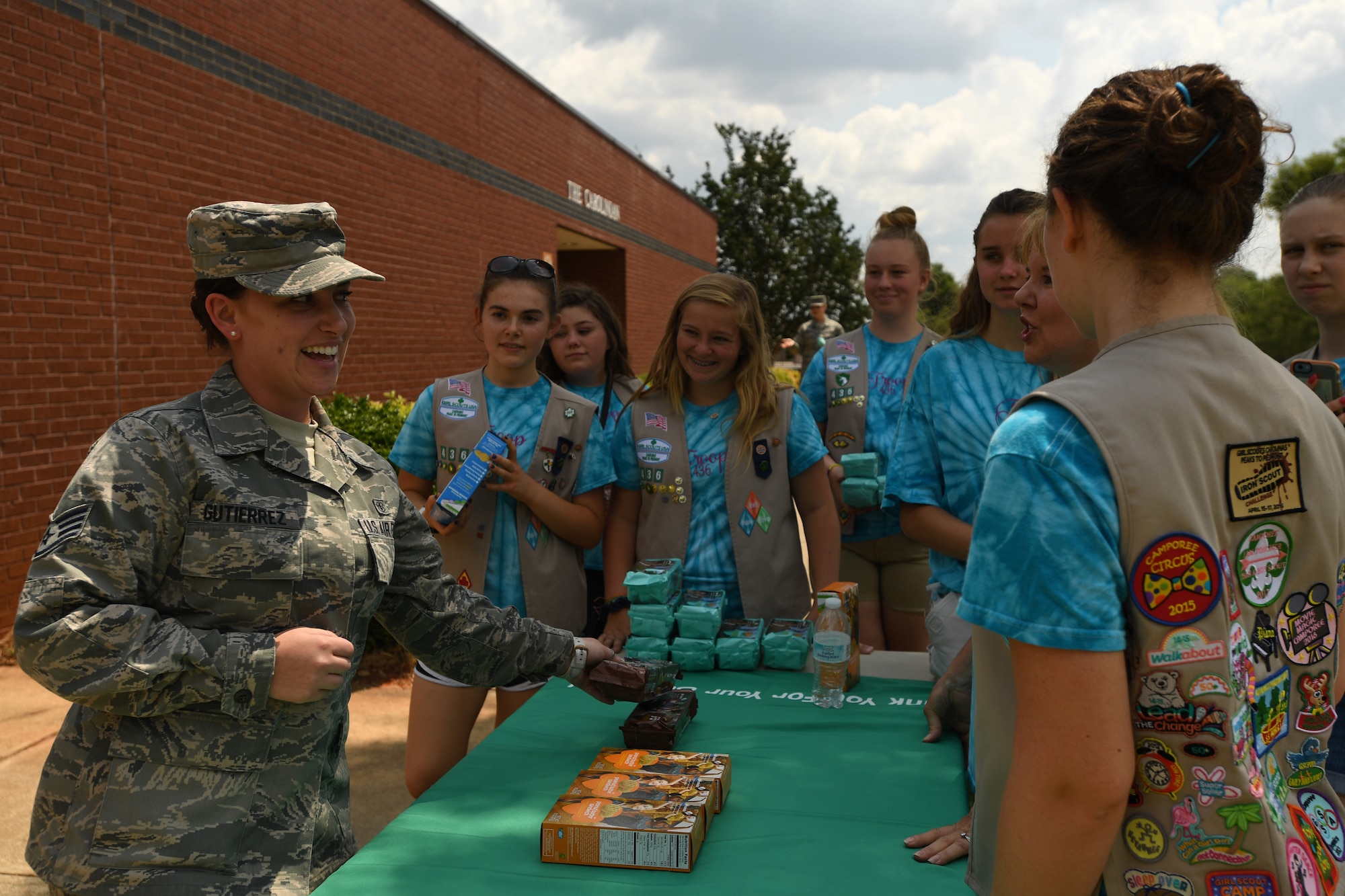 U.S. Air Force Staff Sgt. Amanda Gutierrez, 145th Medical Group, picks up her favorite  box of cookies from Girl Scouts of Troop 20436, Denver, N.C., as they volunteer during the fifth annual visit to the North Carolina Air National Guard Base, Charlotte Douglas International Airport, June 9, 2018. This is part of a council-wide service project, called Operation Sweet Treat, where Girl Scouts collect cookies to give to U.S. military members serving in the United States and deployed overseas.