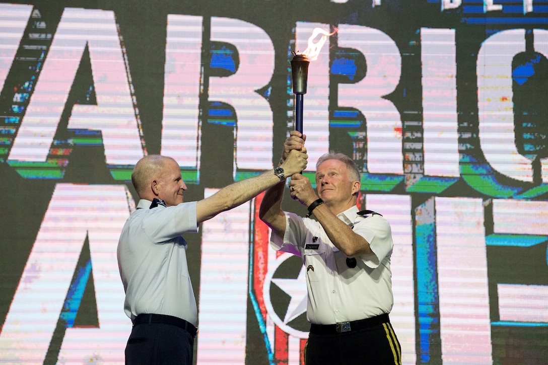 Army Gen. Raymond A. Thomas III, commander of U.S. Special Operations Command, accepts the Department of Defense Warrior Games torch from Air Force Vice Chief of Staff Gen. Stephen W. Wilson during closing ceremonies for the 2018 games at the U.S. Air Force Academy in Colorado Springs, Colo., June 9, 2018. DoD photo by EJ Hersom
