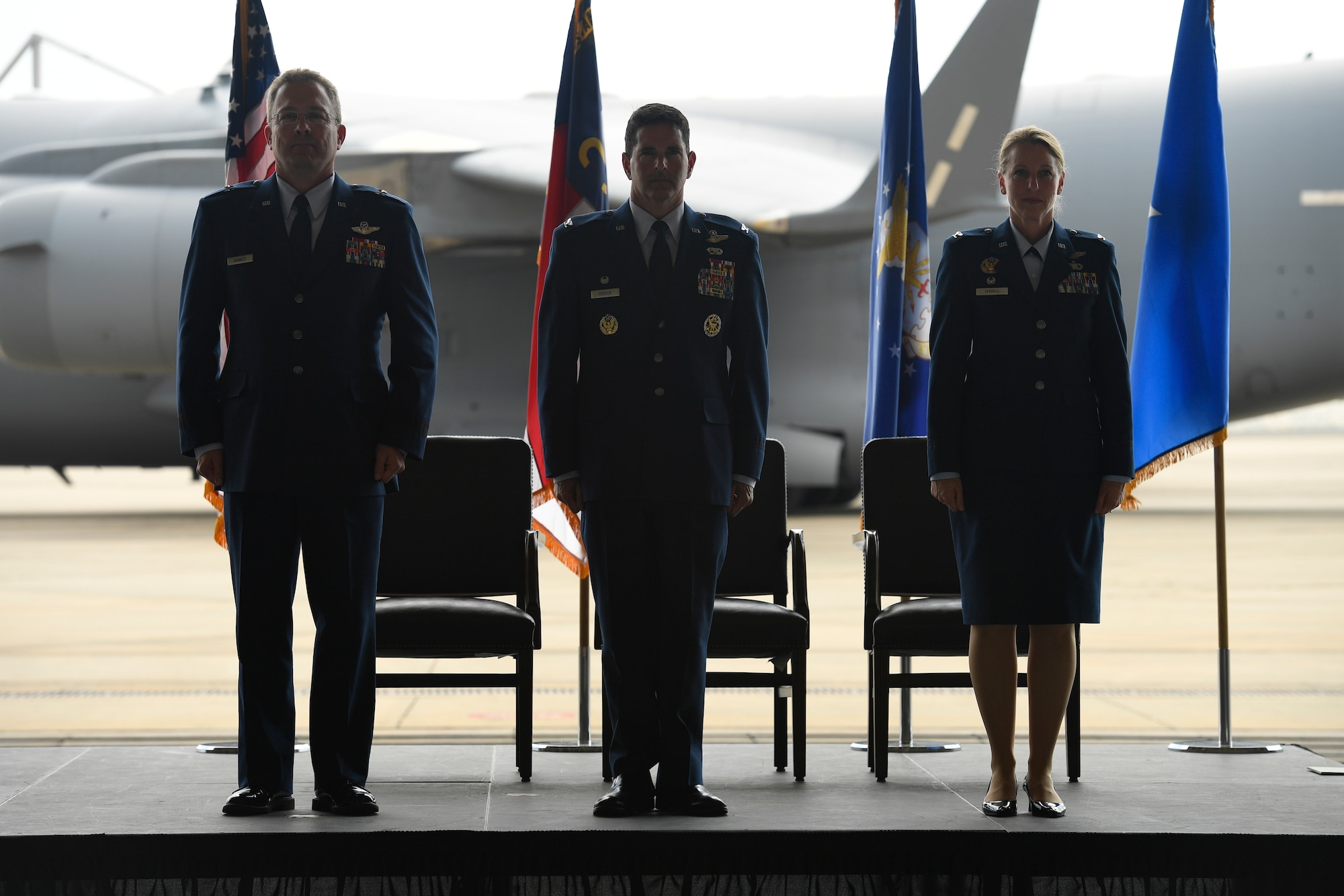 U.S. Air Force Brig. Gen. Thomas Kennett (left), Assistant Adjutant General for Air, North Carolina National Guard (NCANG), Col. Michael Gerock (center), commander of the 145th Airlift Wing (AW), and Col. Bryony Terrell (right), stand at attention prior to the passing of the guide-on which signifies the official change of command held at the NCANG Base, Charlotte Douglas International Airport, June 9, 2018. Gerock will relinquish command to Col. Bryony Terrell who will be the the first female commander for the 145th AW.