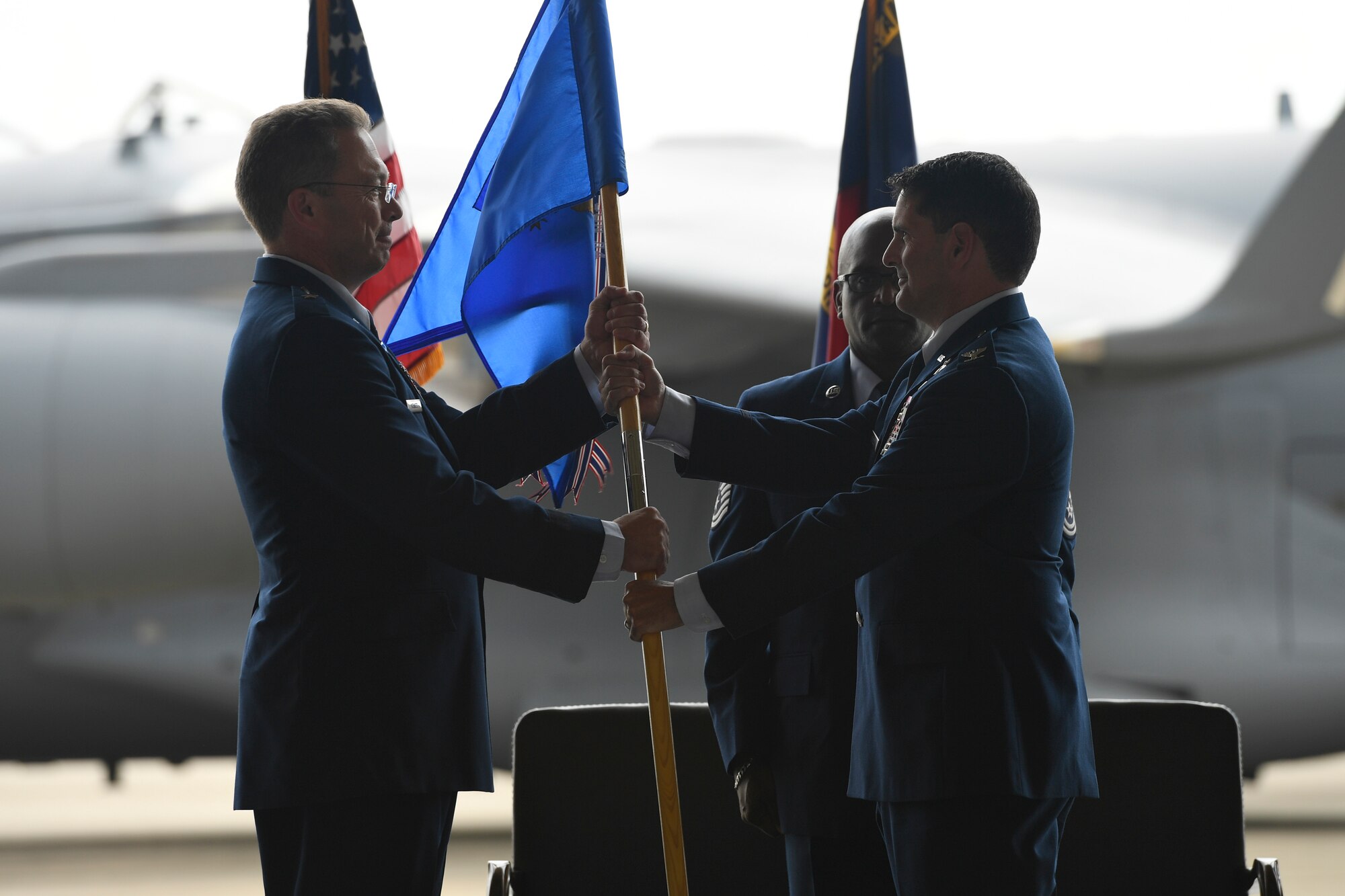 U.S. Air Force Col. Michael Gerock (right) relinquishes command of the 145th Airlift Wing (AW) and passes the guide-on to Brig. Gen. Thomas Kennett (left), Assistant Adjutant General for Air, North Carolina National Guard (NCANG), during a Change of Command Ceremony held at the NCANG Base, Charlotte Douglas International Airport, June 9, 2018. Gerock spearheaded the 145th AW transition from the C-130 Hercules aircraft to the C-17 Globemaster III aircraft during his tenure.