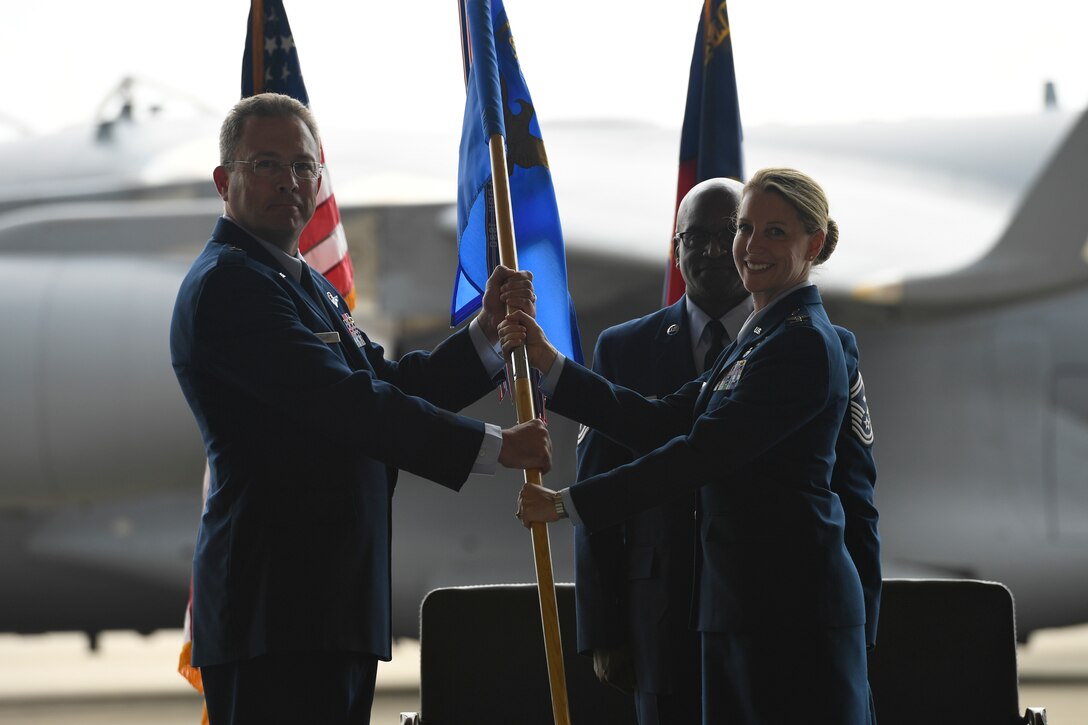 U.S. Air Force Col. Bryony Terrell, assumes command of the 145th Airlift Wing by accepting the guid-on from Brig. Gen. Thomas Kennett (left), Assistant Adjutant General for Air, North Carolina National Guard (NCANG), during a Change of Command Ceremony held at the NCANG Base, Charlotte Douglas International Airport, June 9, 2018. Terrell is the first female commander for the 145th AW and will continue the units transition to the C-17 Globemaster III.