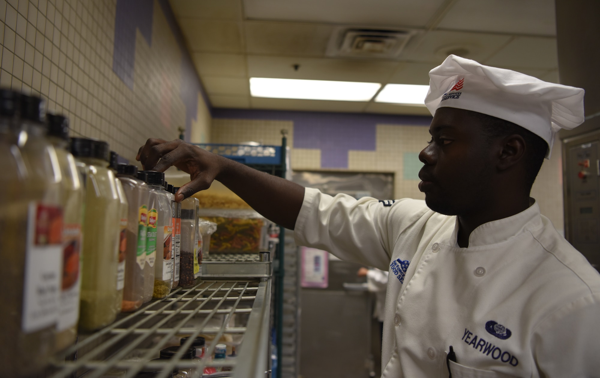 Airman 1st Class Kurt Yearwood, a 56th Force Support Squadron food service apprentice, searches through different spices as he prepares a freshly cooked dinner at the Hensman Dining Facility June 7, 2018 at Luke Air Force Base, Ariz.