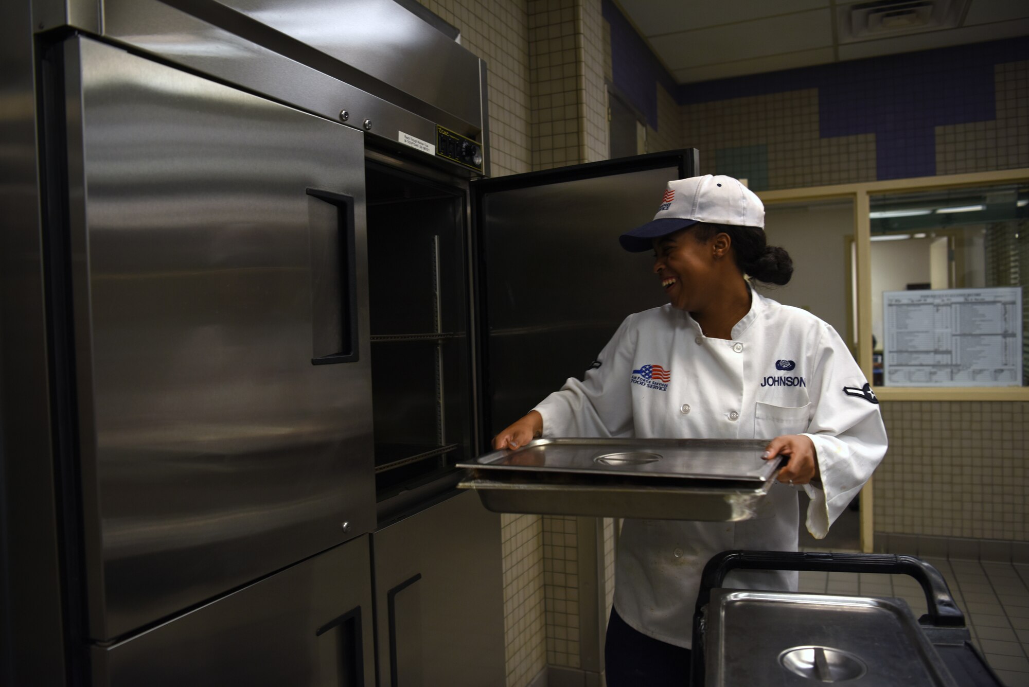 Airman Vanee Johnson, 56th Force Support Squadron services apprentice, places freshly cooked food in an oven at the Hensman Dining Facility June 7, 2018, at Luke Air Force Base, Ariz.