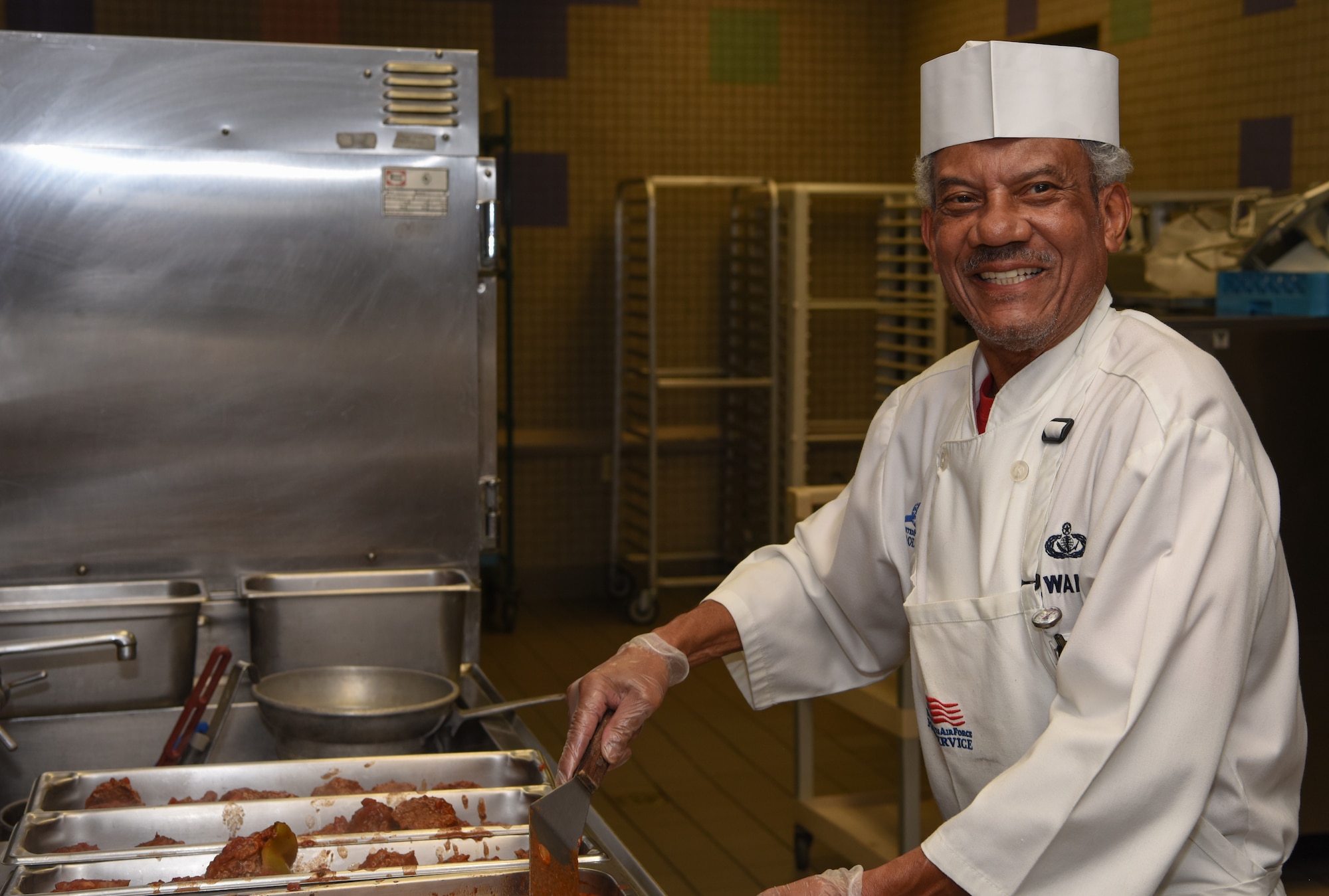 Septus Wallace, a 56th Force Support Squadron food services work leader, smiles as he prepares stuffed peppers for lunch at the Hensman Dining Facility June 8, 2018 at Luke Air Force Base, Ariz.