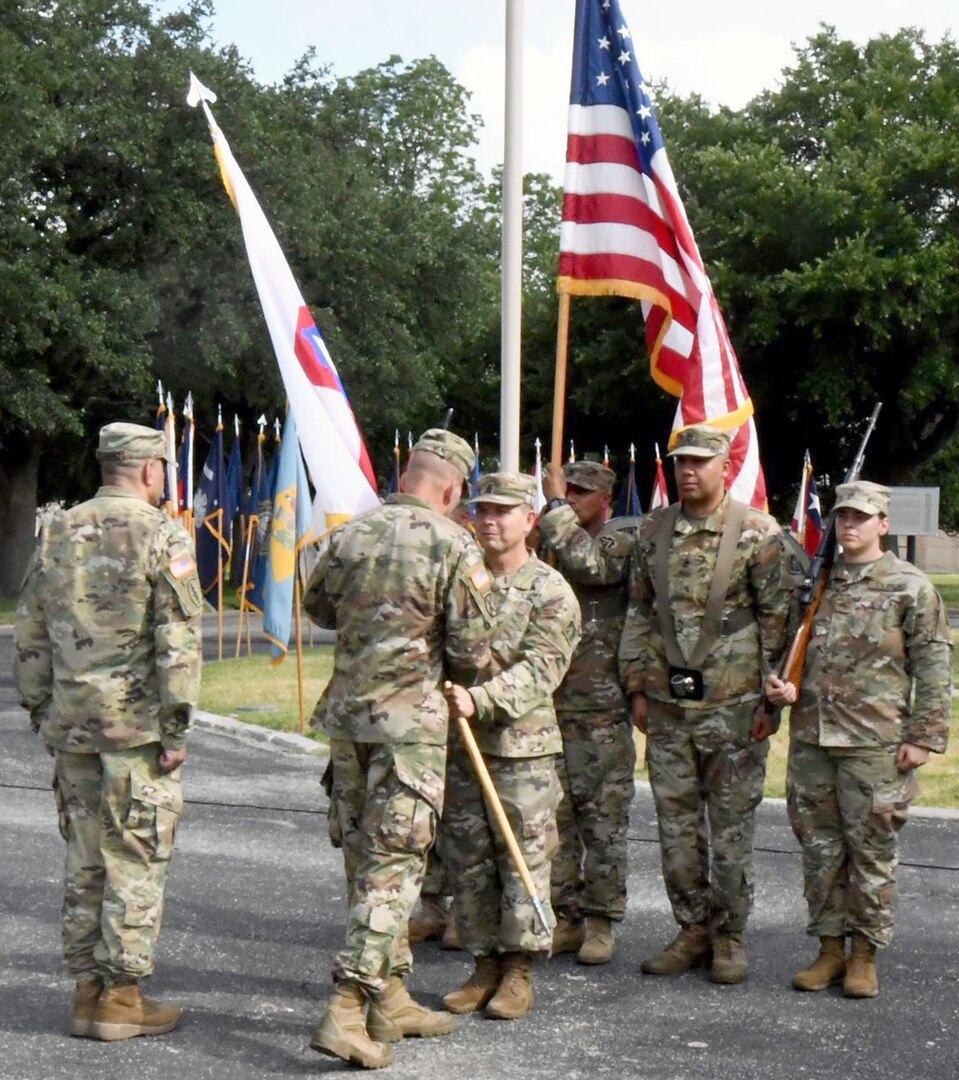 Sgt. Maj. Ronald E. Orosz, outgoing command sergeant major, U.S. Army North, hands off the ARNORTH colors to Lt. Gen. Jeffrey Buchanan, commanding general, ARNORTH, during a change of responsibility ceremony at the Quadrangle at the Quadrangle at Joint Base San Antonio-Fort Sam Houston June 8.